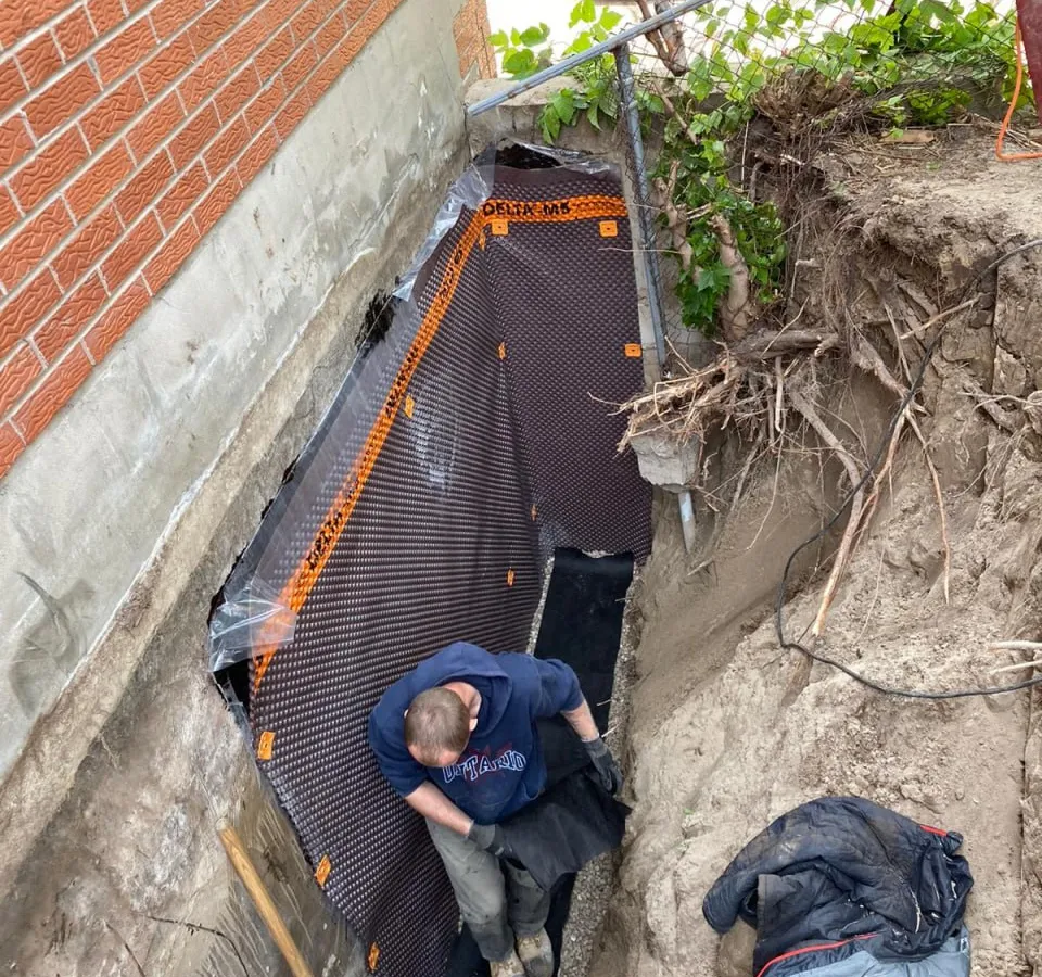 Exterior foundation excavation for waterproofing in Barrie multi-unit building