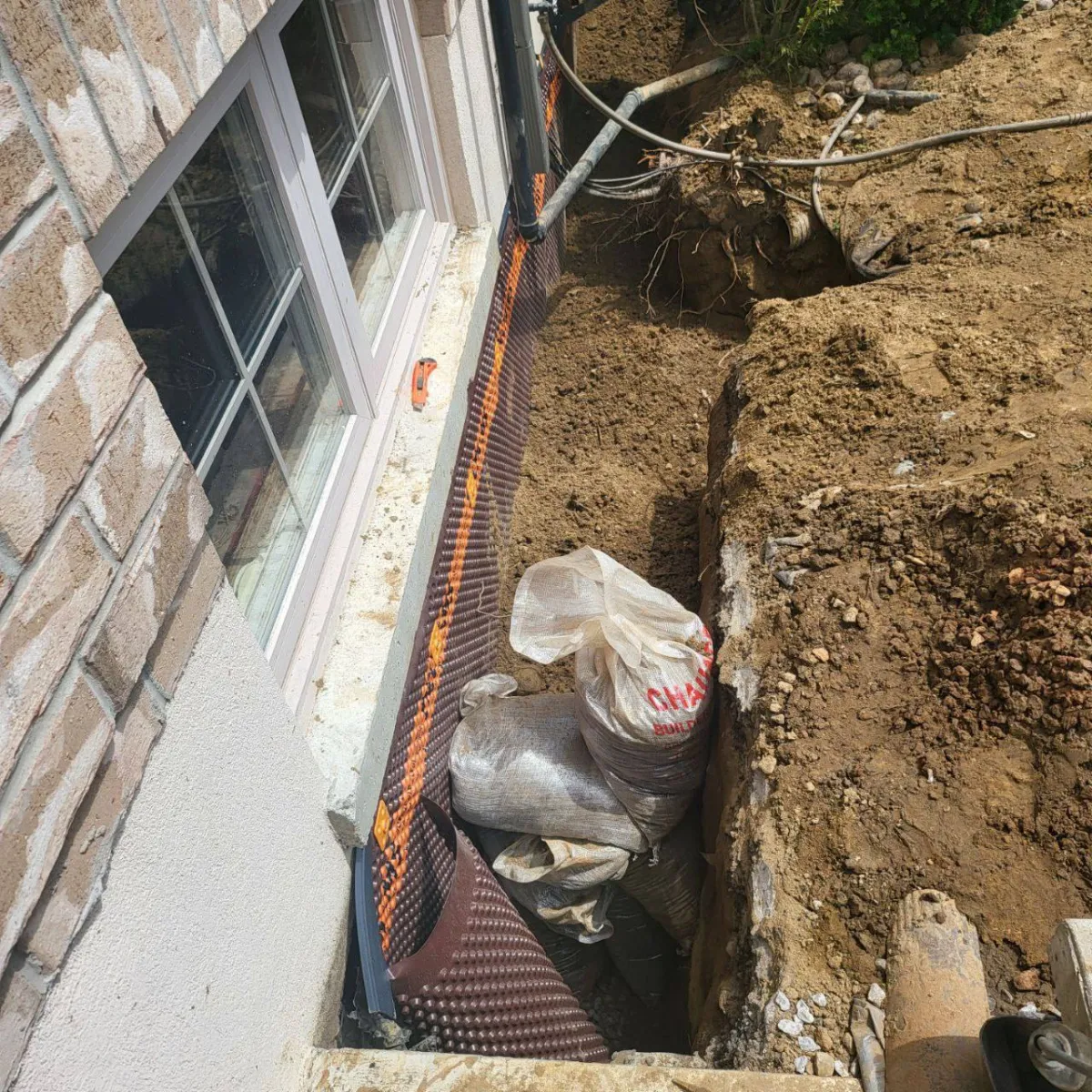 Completed exterior waterproofing with drainage system and backfill at Mount Albert residence